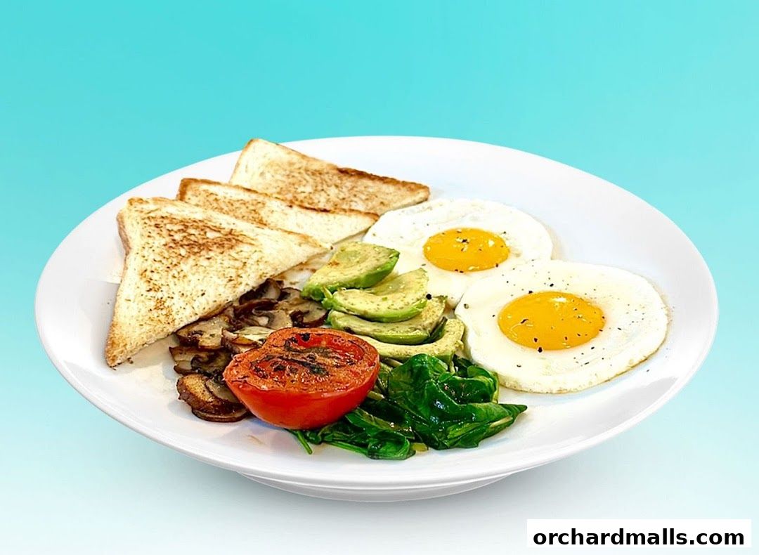 A delicious breakfast plate with fried eggs, toast, avocado, mushrooms, tomato, and spinach.