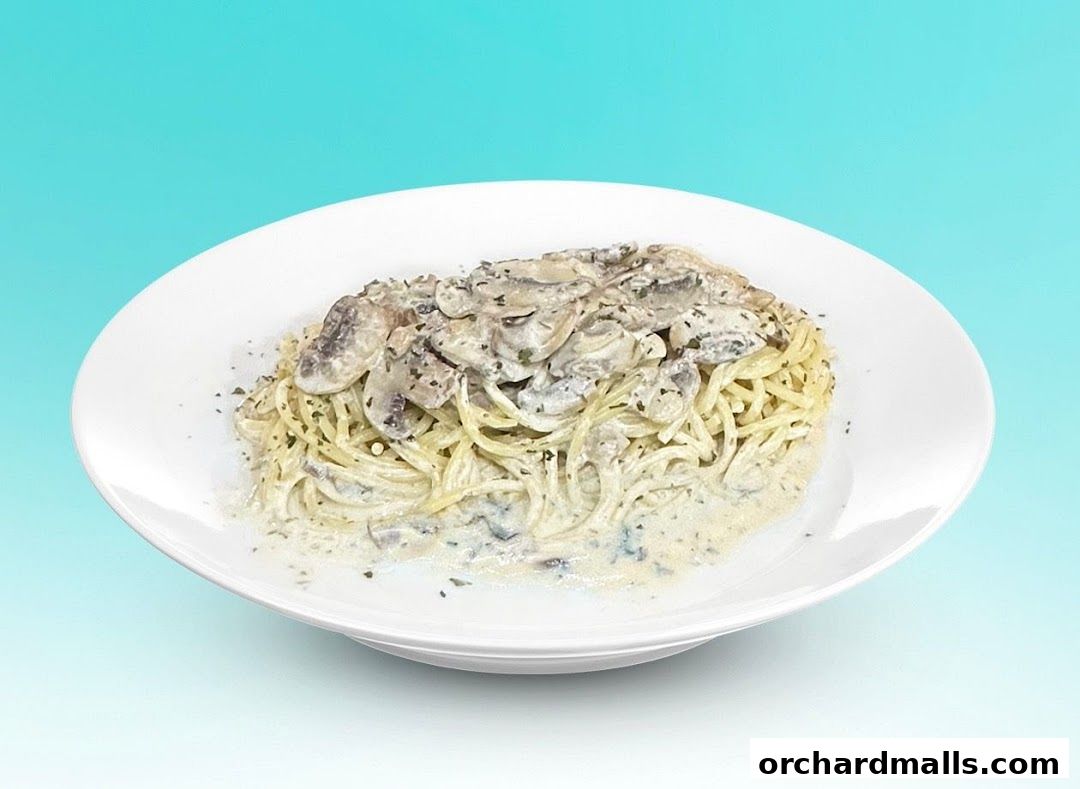 A plate of spaghetti with creamy mushroom sauce and herbs.