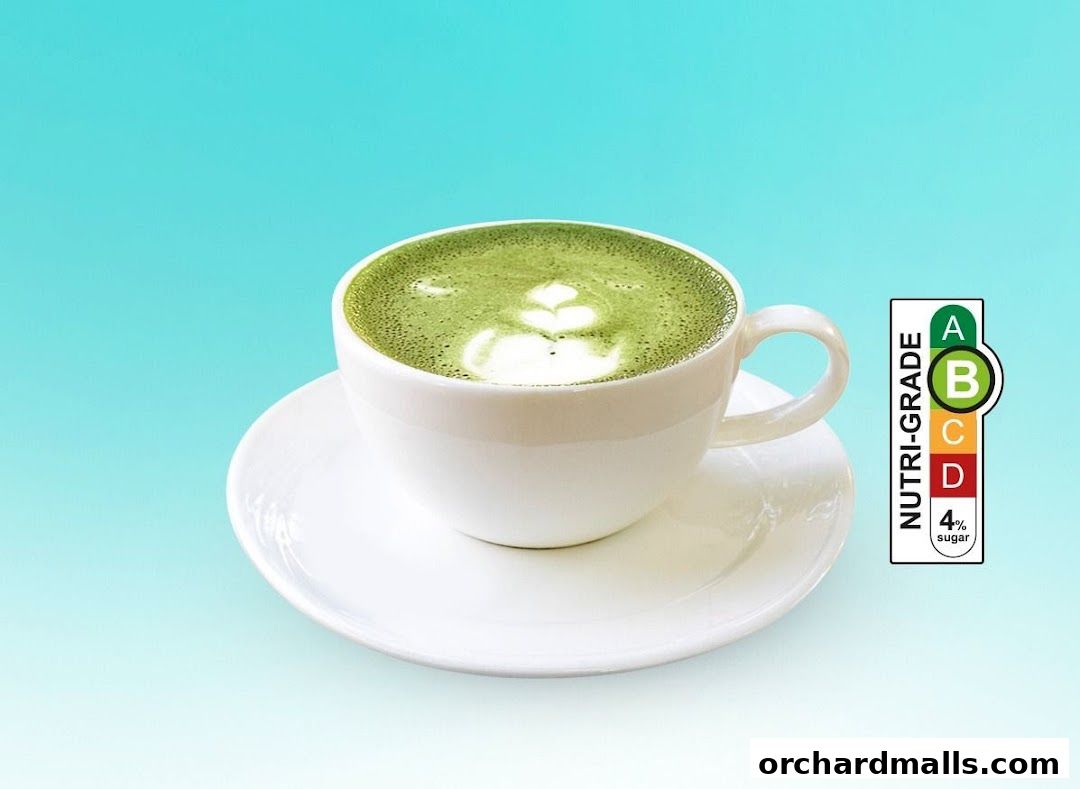 A white cup of matcha latte with latte art on a saucer, next to a nutri-grade label.