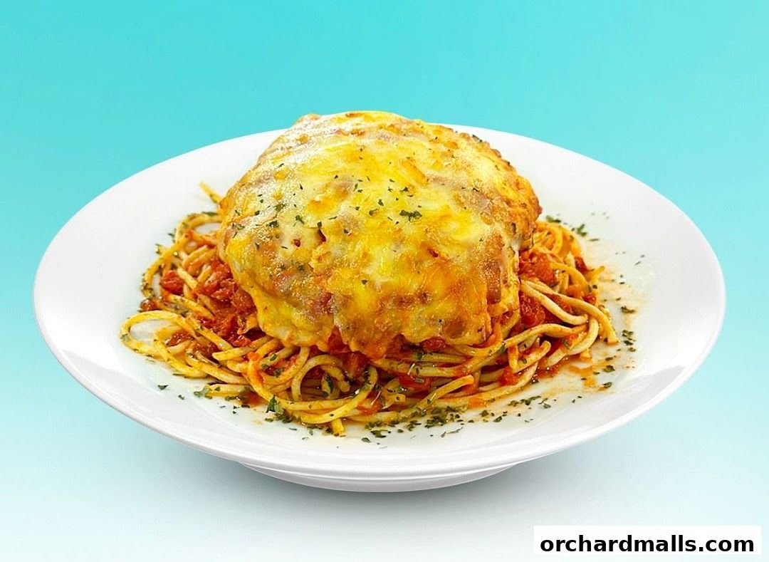 A delicious plate of spaghetti topped with melted cheese and marinara sauce.