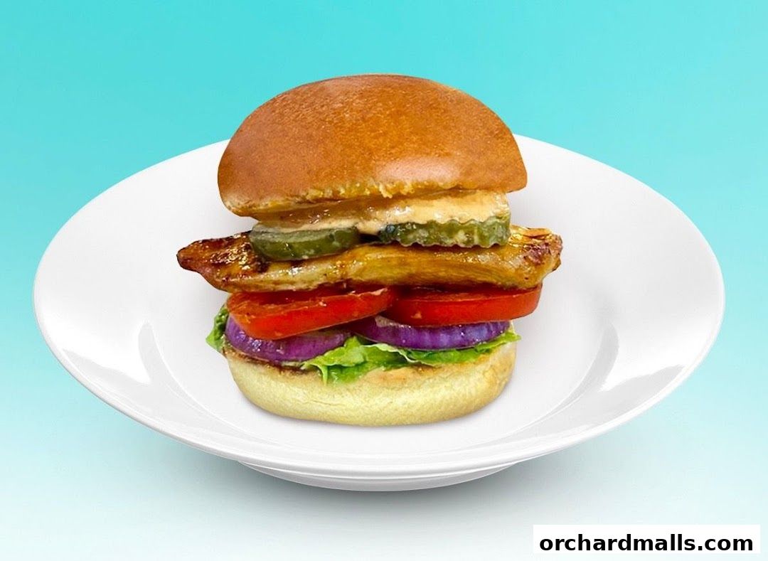A delicious, stacked burger with fresh ingredients on a white plate.