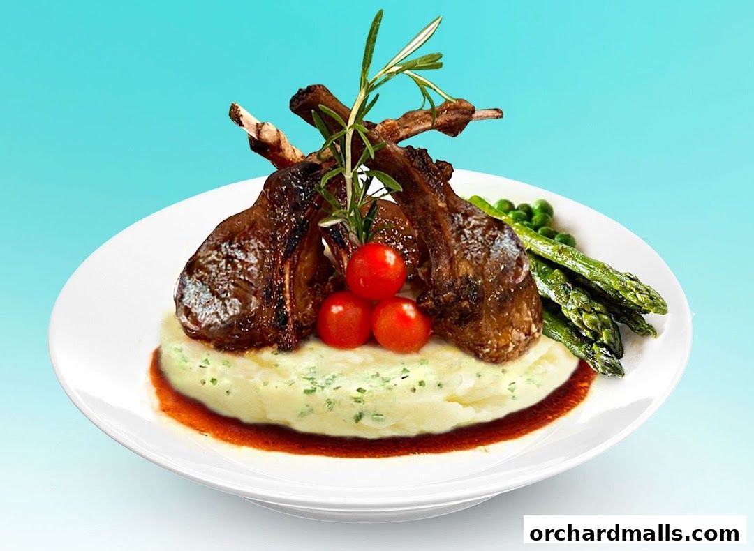 A plate of grilled lamb chops with mashed potatoes, asparagus, and cherry tomatoes.