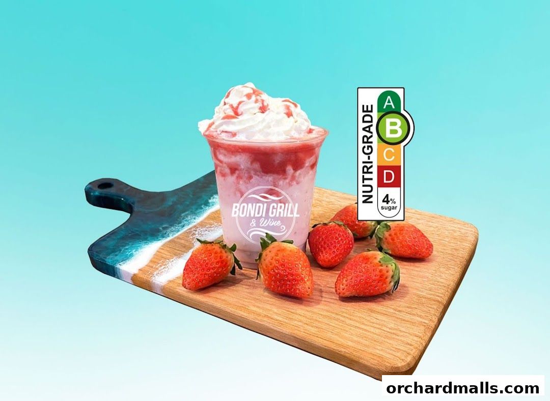 A strawberry smoothie with whipped cream and strawberries on a wooden board.