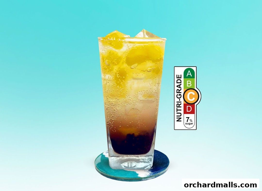 A tall glass of iced beverage with fruit slices and a nutri-grade label.
