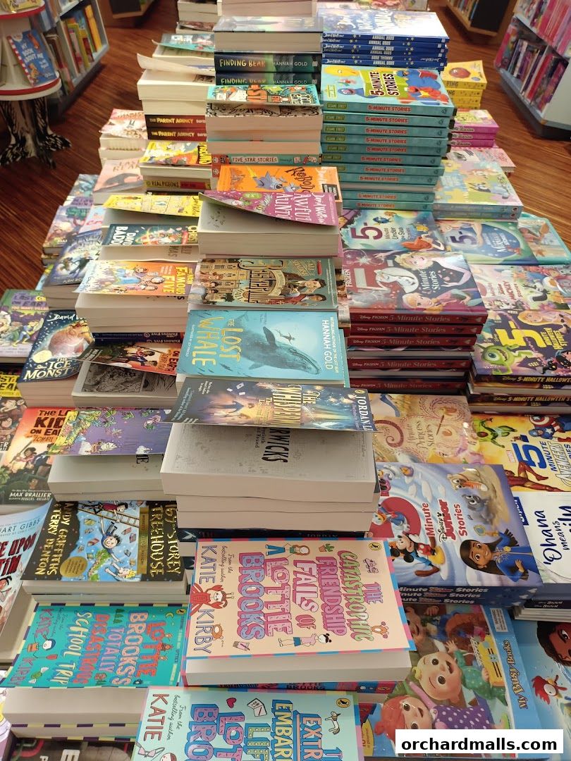 A wide selection of children's books are neatly stacked and displayed on tables.