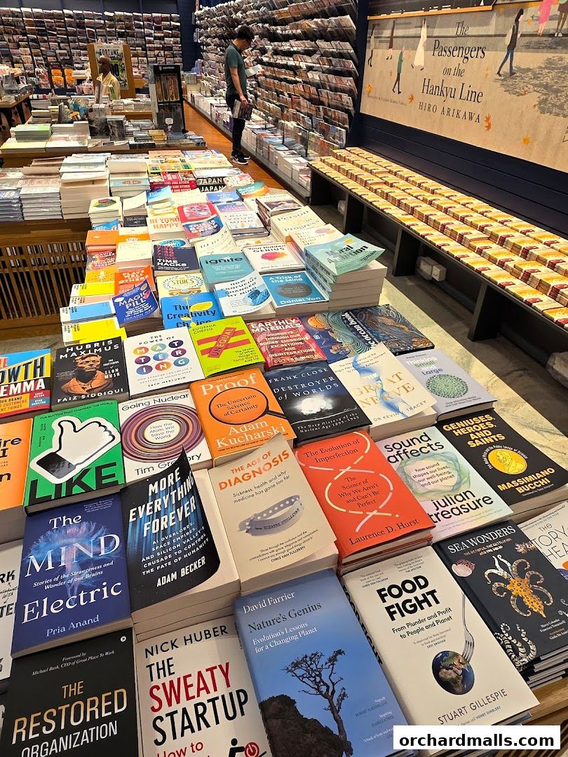 A wide selection of books displayed on tables and shelves inside a bookstore.