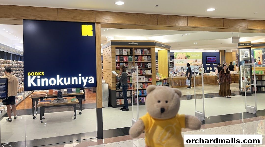 Entrance to Books Kinokuniya Singapore Main Store with displays of books and shoppers.