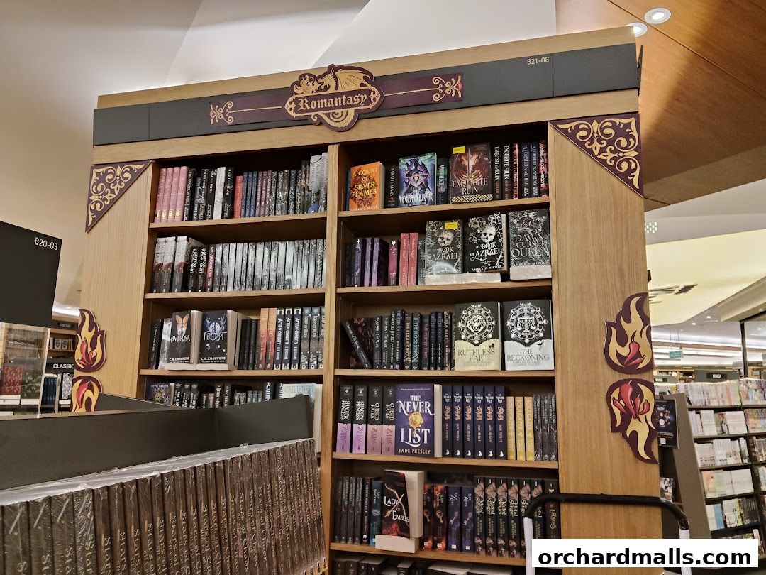 A display of books in a store, featuring a 'Romantasy' section with fantasy novels.
