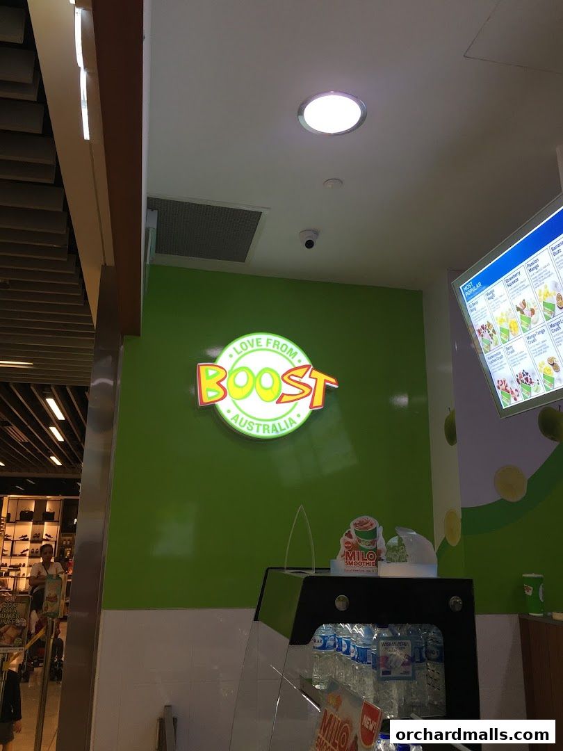 The interior of a Boost Juice shop with its logo and a digital menu board.