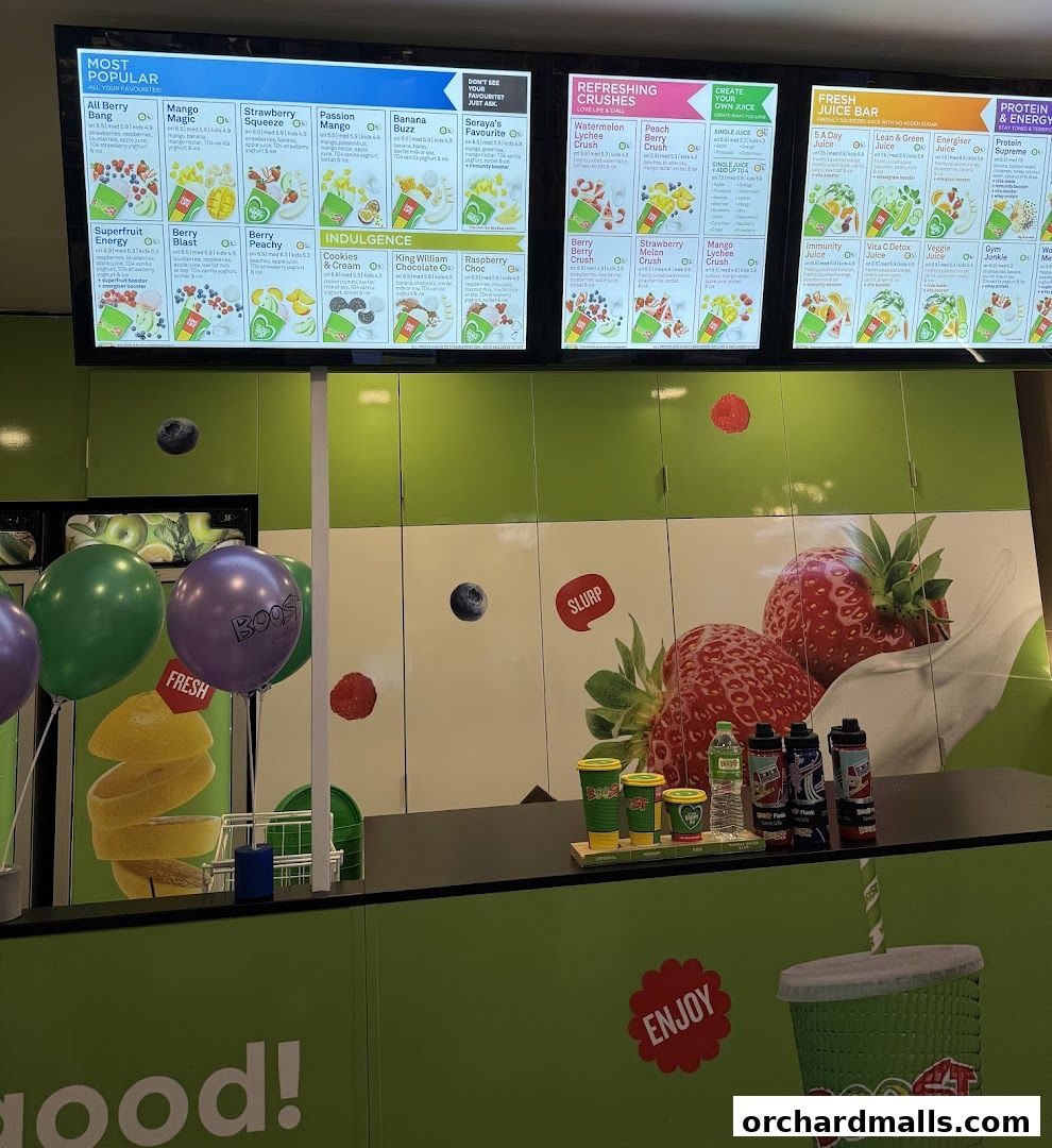 Boost Juice shop interior with menu boards, balloons, and promotional cups.