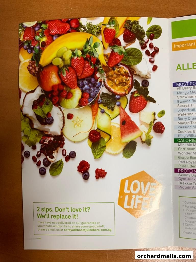 A vibrant display of fresh fruits and a menu with juice options from Boost Juice.