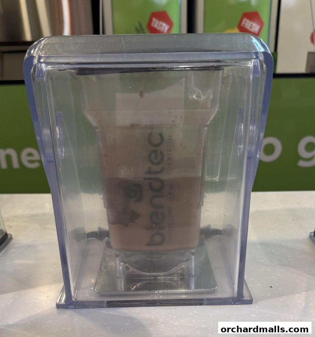 A close-up of a blender jug with a chocolate-colored drink inside, branded 'Blendtec'.