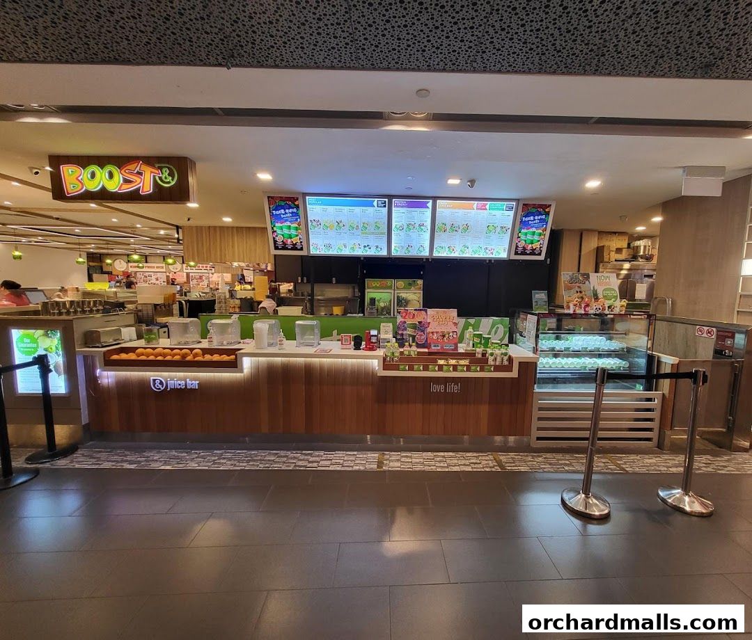 A Boost Juice shop counter with a menu, fresh fruits, and chilled drinks displayed.