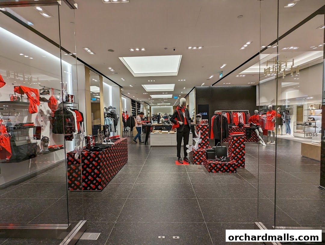 Interior view of a BOSS store showcasing clothing on mannequins and racks.