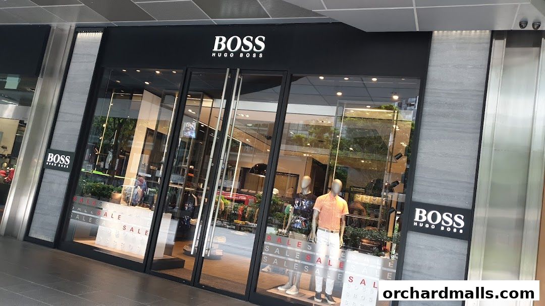 The exterior of a BOSS Hugo Boss clothing store with mannequins in the window.