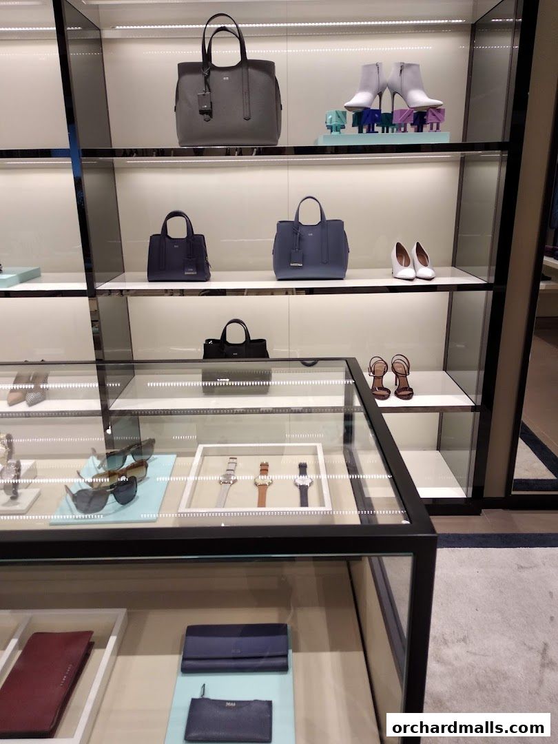 A display of luxury handbags, shoes, watches, and wallets from the BOSS brand.
