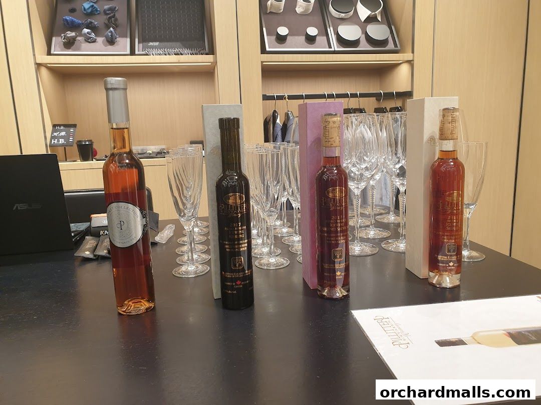 Bottles of wine and champagne flutes are displayed on a table in a retail setting.