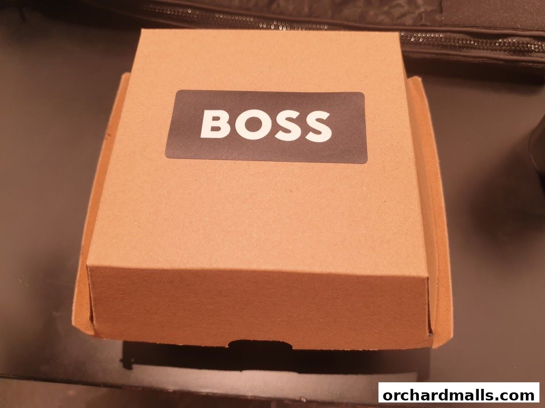A closed cardboard box with the BOSS logo on a dark surface.