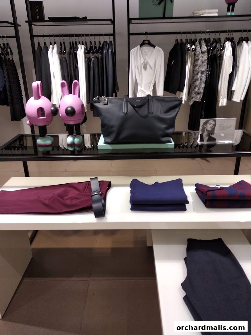 A display of BOSS brand clothing and accessories, including handbags and apparel.