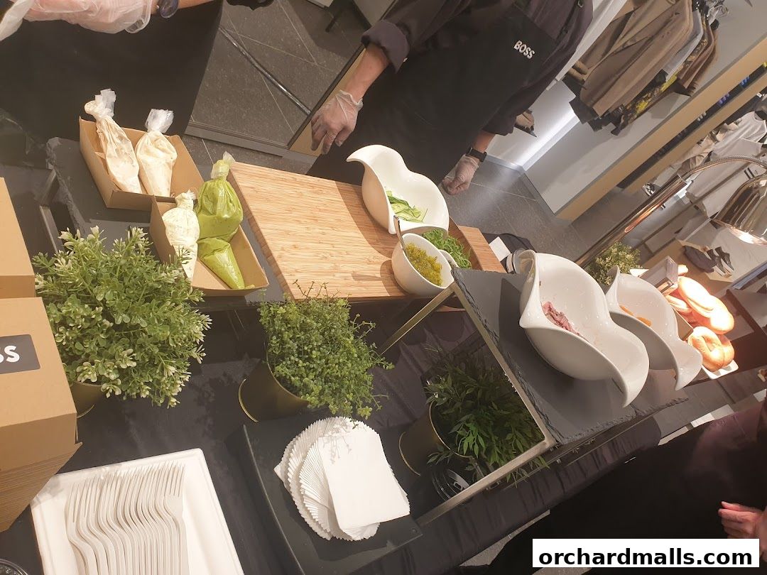 A BOSS branded apron is worn by a person preparing food with various ingredients and serving dishes.
