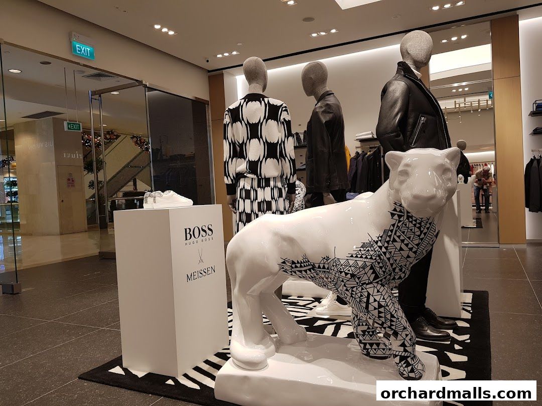 Mannequins and a decorative jaguar statue display BOSS fashion and footwear.