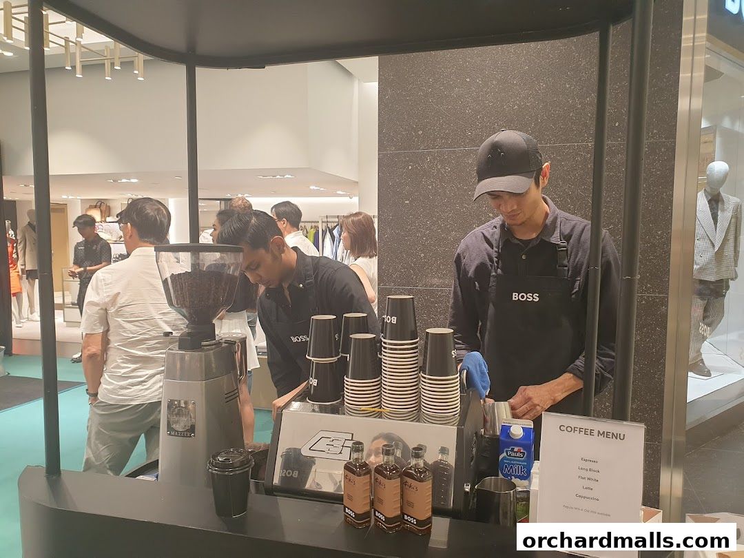 A BOSS branded coffee stand with baristas serving customers in a retail store.