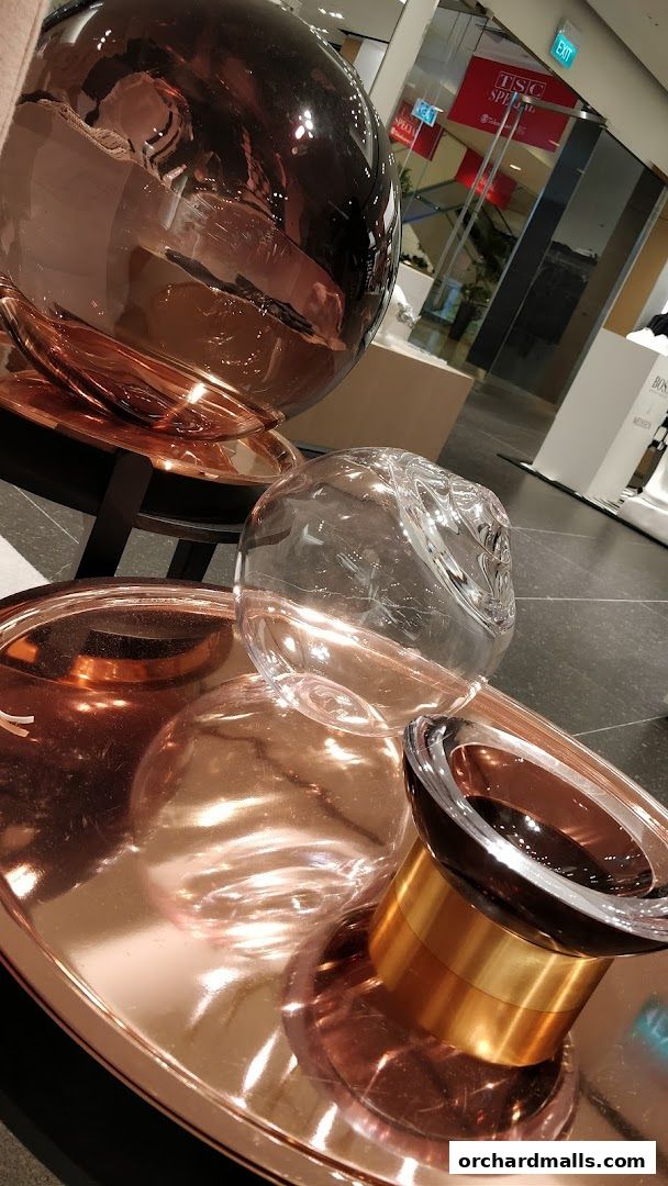 Close-up of decorative metallic spheres and trays with reflections.