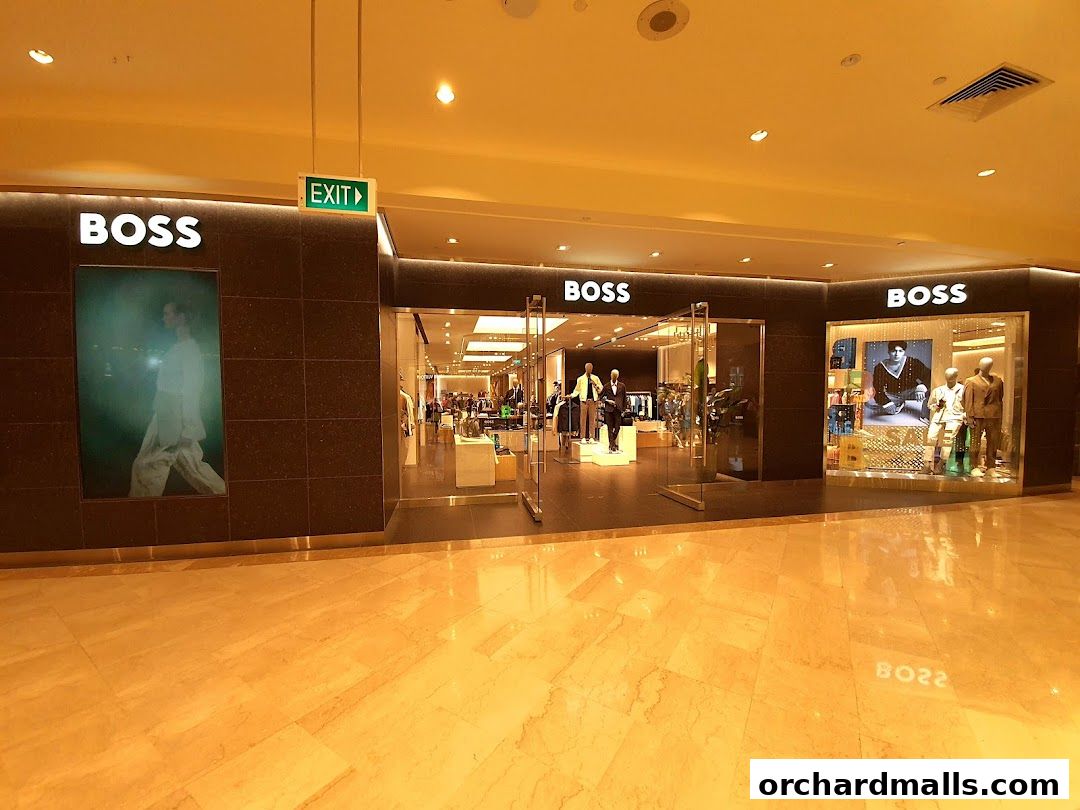 The exterior of a BOSS store with mannequins displaying clothing in the windows.