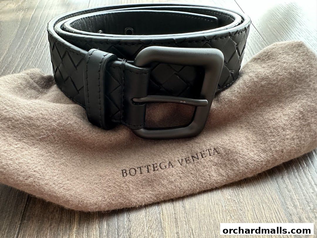 A black Bottega Veneta belt with signature Intrecciato weave and a dust bag.