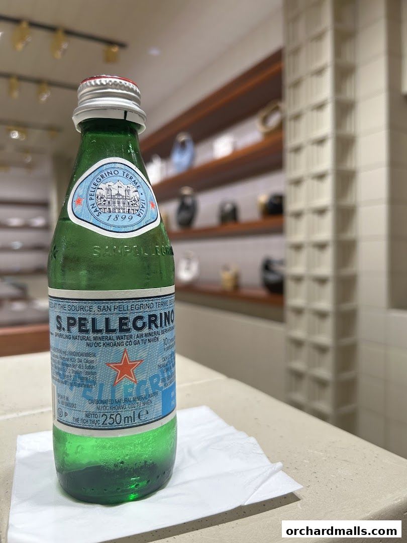 A chilled bottle of S.Pellegrino sparkling water sits on a napkin.