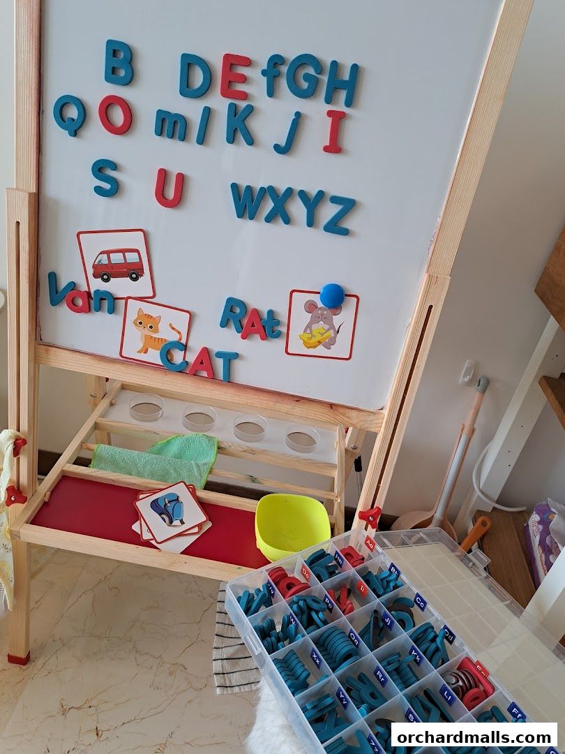 A whiteboard with magnetic letters and learning cards for children's education.