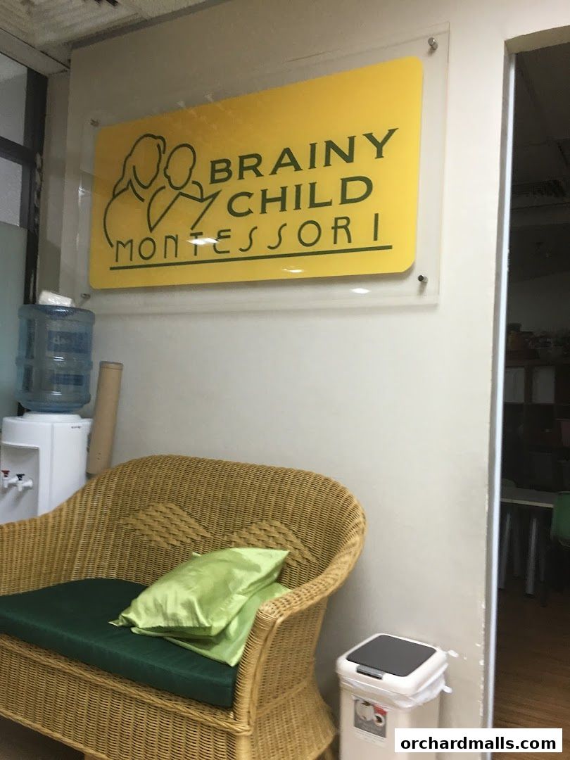 A sign for Brainy Child Montessori Learning Centre above a wicker bench and water cooler.