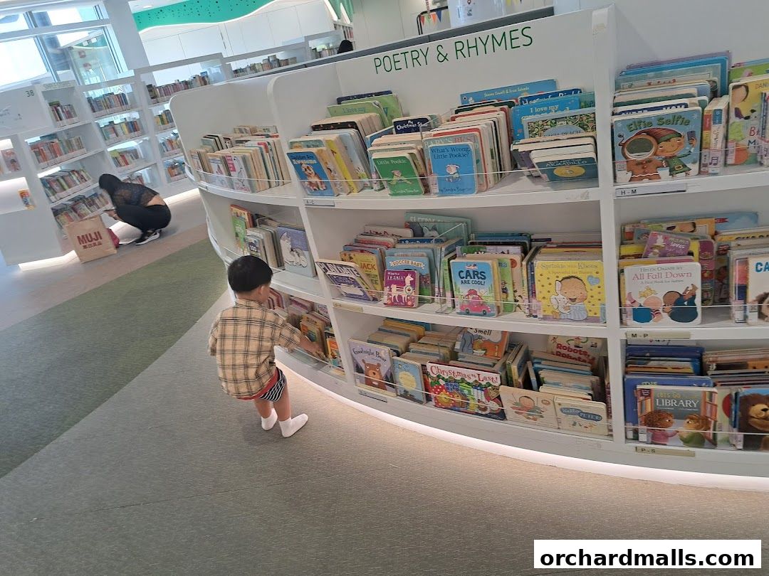A child browses books in a brightly lit library with shelves full of children's literature.