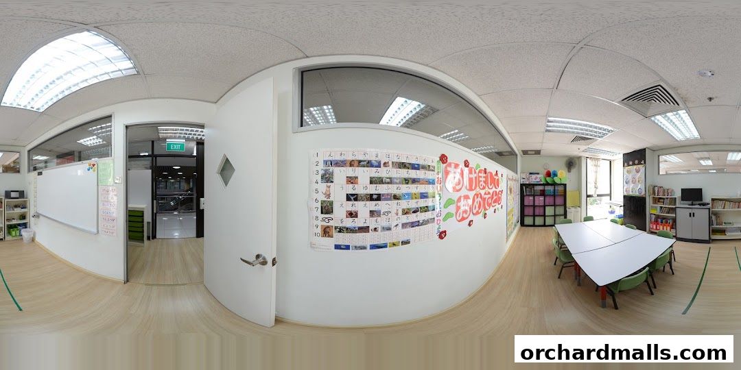 Interior of a Montessori learning center with a whiteboard, tables, chairs, and educational materials.
