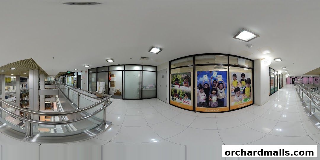 Interior view of a shopping mall corridor with shops and a learning center.