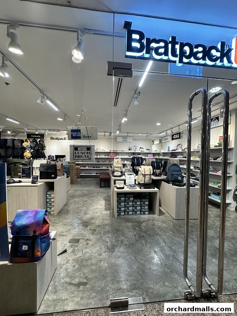 The entrance of Bratpack Wheelock Place, showcasing various backpacks and bags on display.