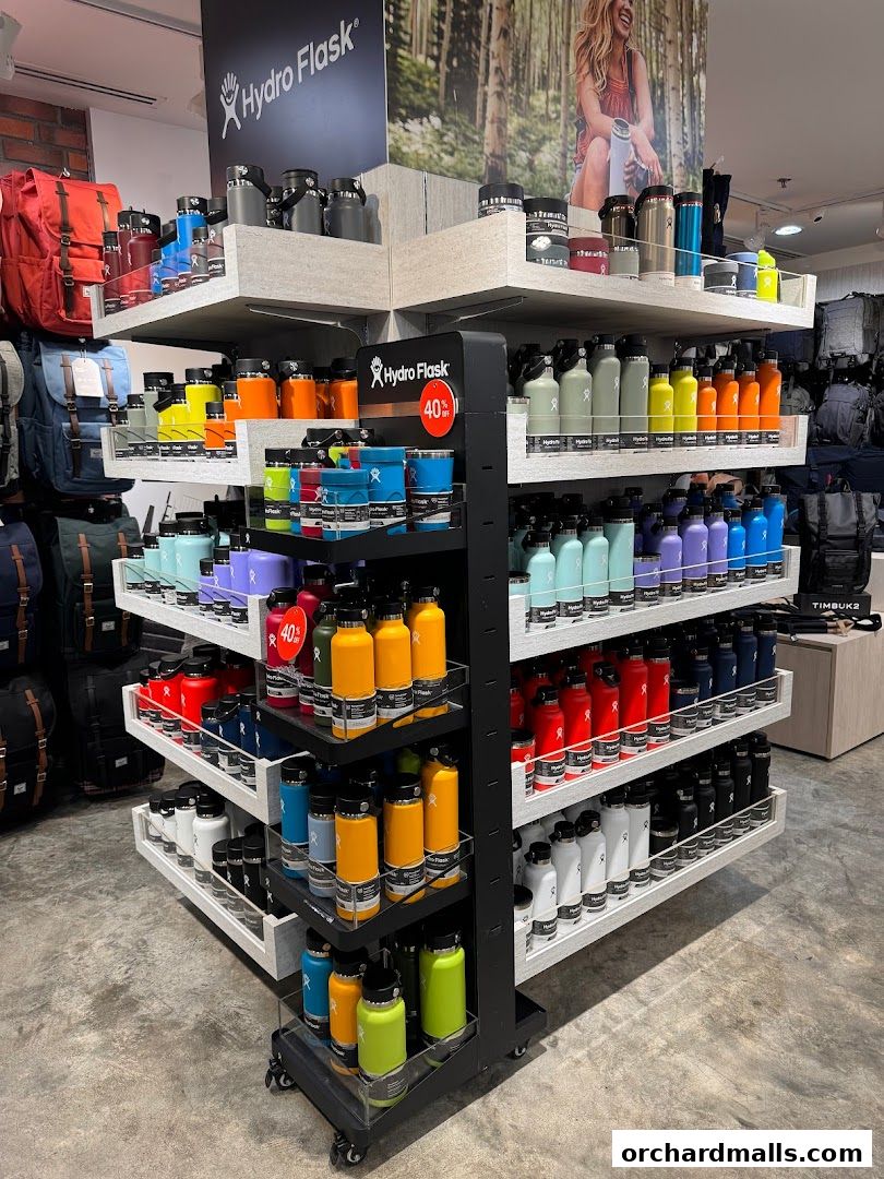 A display of colorful Hydro Flask bottles and bags in a retail store.