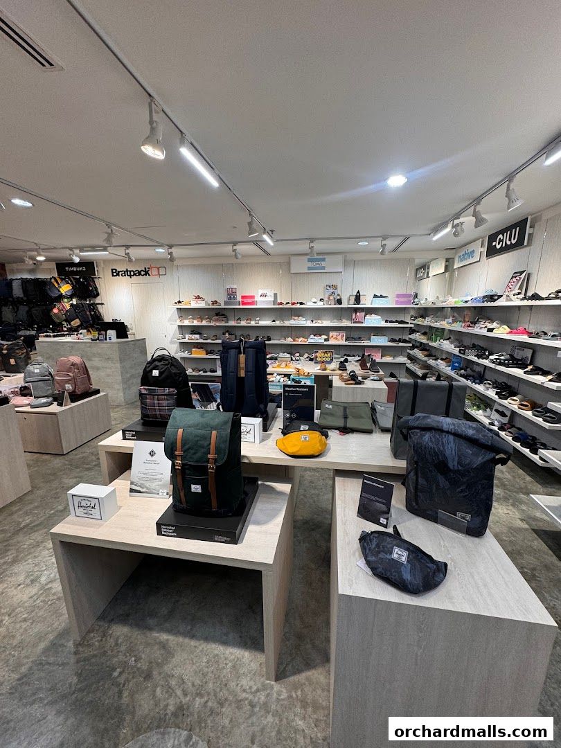 Interior view of Bratpack Wheelock Place showcasing various backpacks, bags, and footwear.