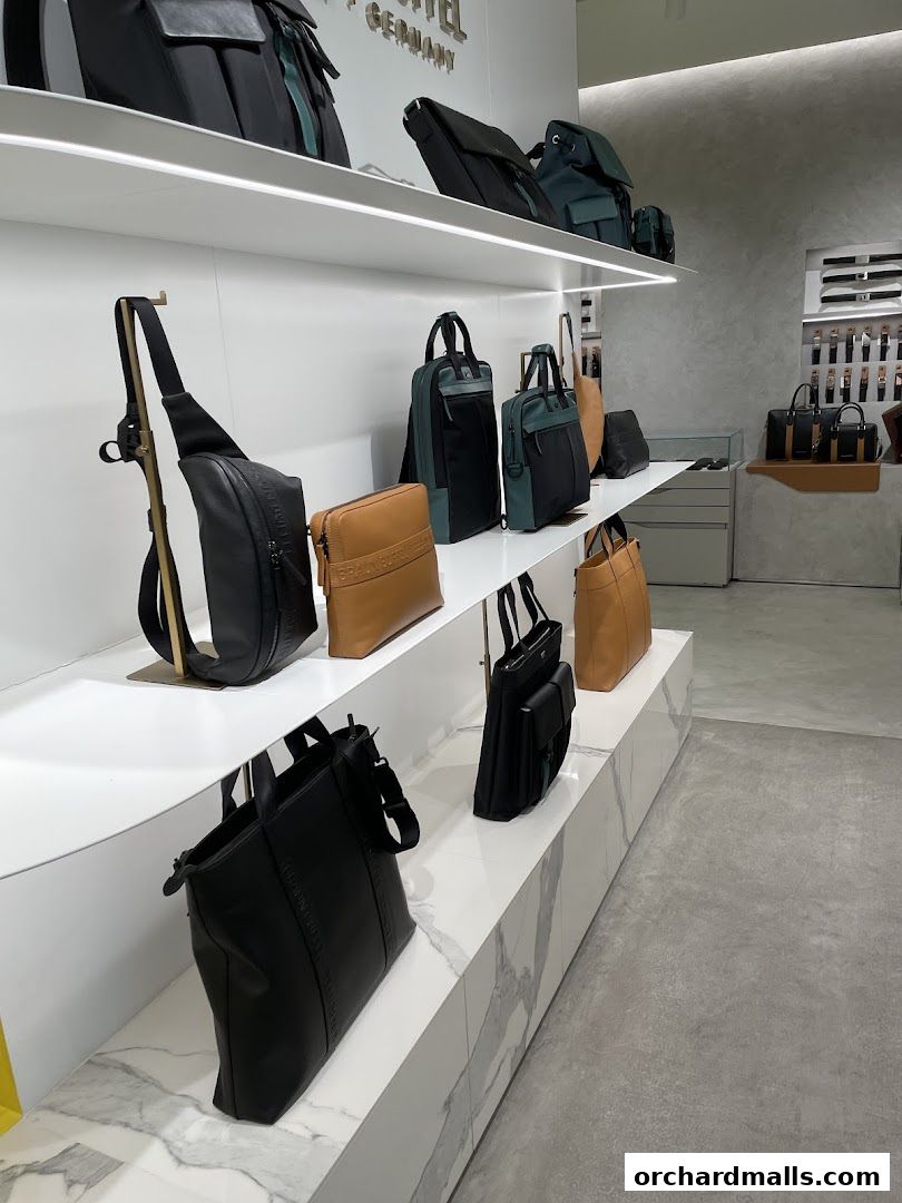 Interior view of a Braun Büffel store showcasing various leather bags on display shelves.