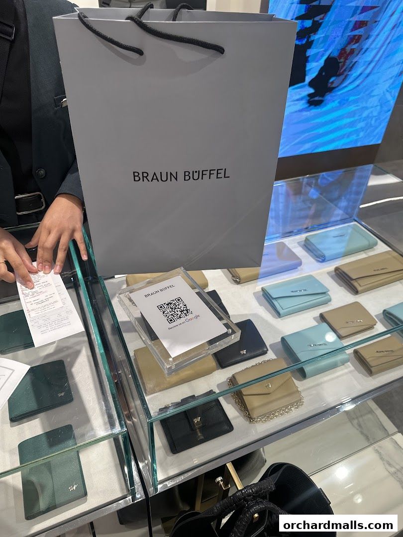 A display of Braun Büffel wallets and a shopping bag in a retail store.