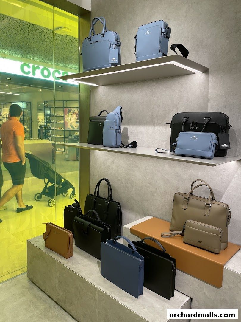 A display of various leather bags, including briefcases and clutches, in different colors.