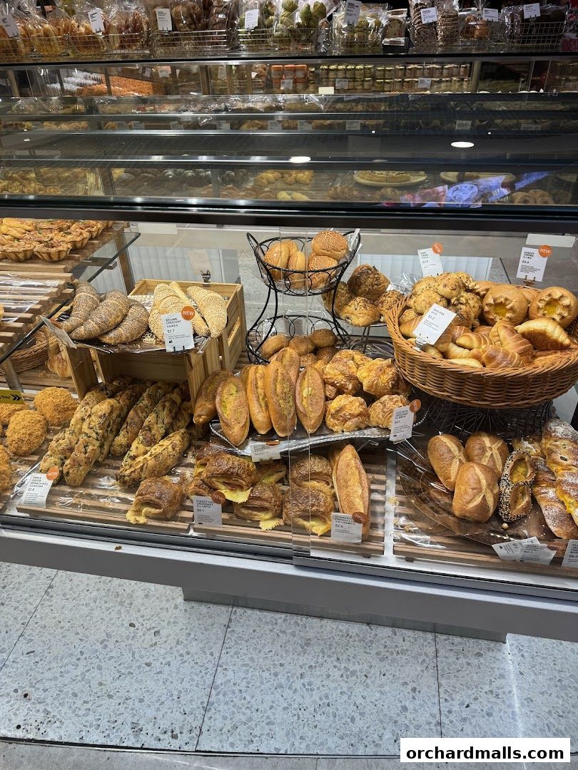 A display case filled with a variety of freshly baked breads, pastries, and baked goods.
