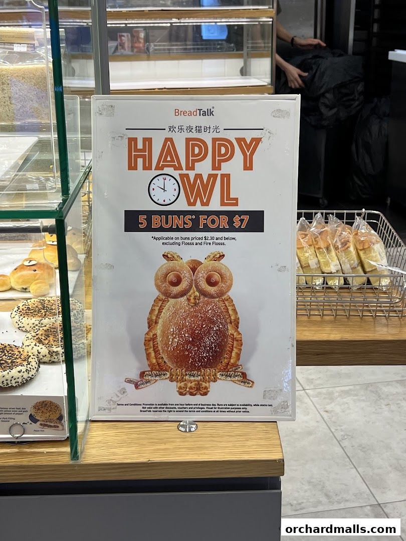 A sign advertising BreadTalk's 'Happy Owl' promotion, offering 5 buns for $7.