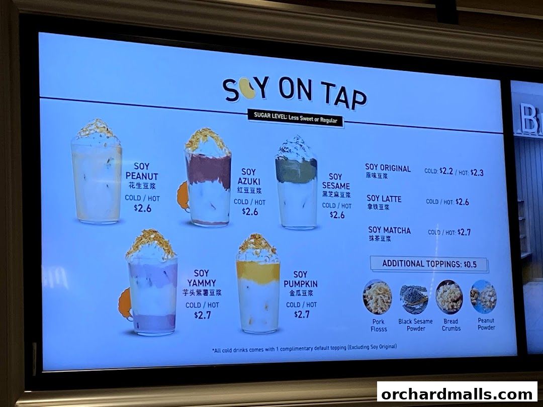 A digital menu board displaying various soy-based drinks with toppings.