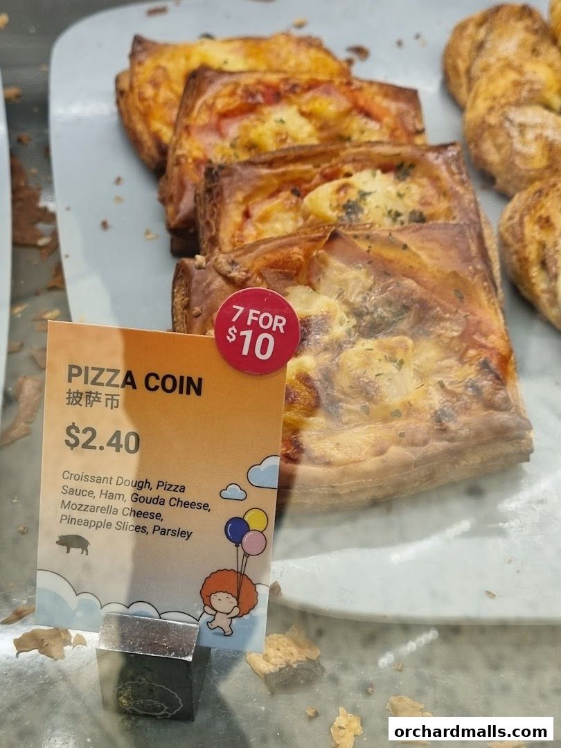 A sign displays a 'Pizza Coin' pastry with its ingredients and price.