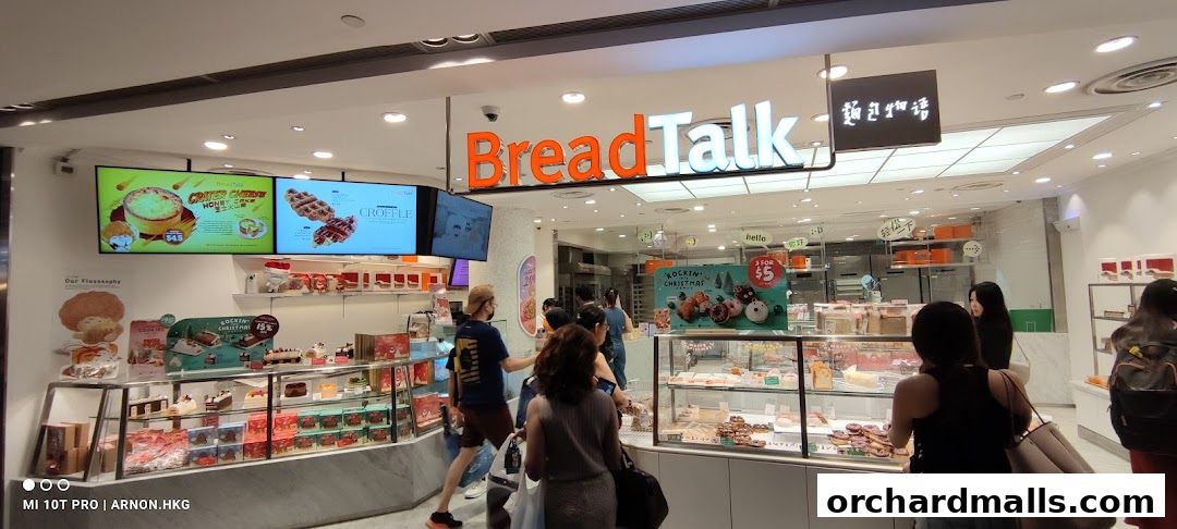 Interior view of a BreadTalk bakery with customers browsing displayed pastries and cakes.