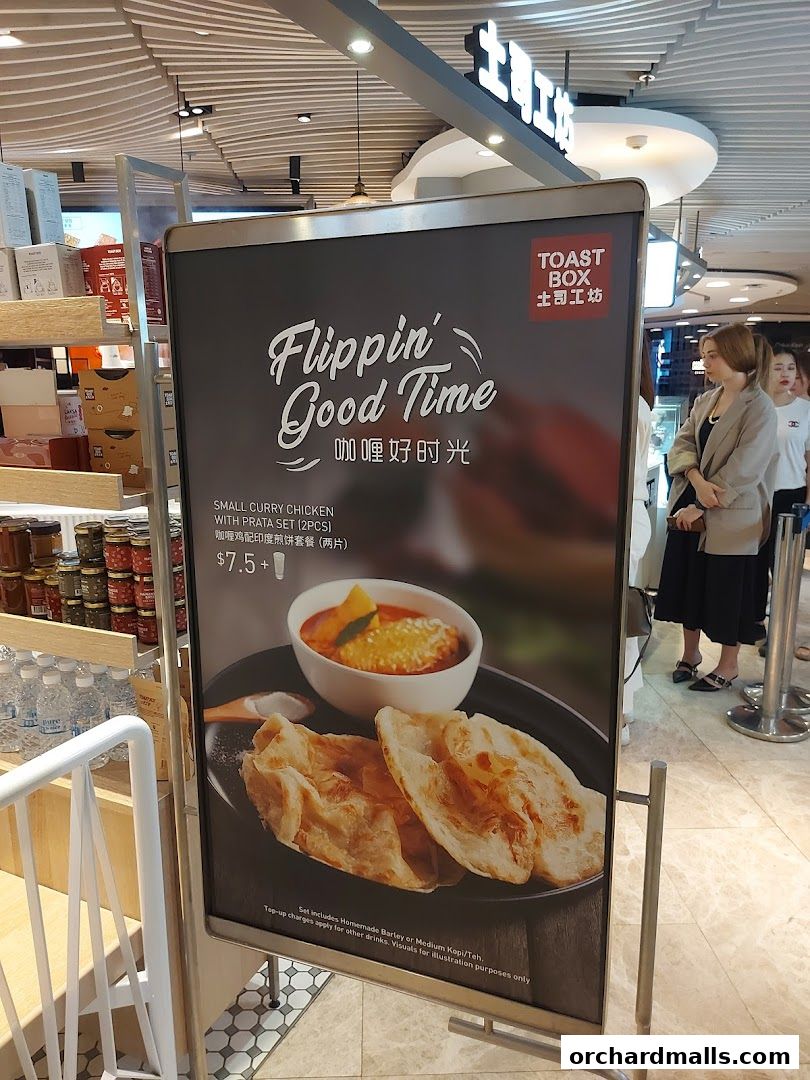 A sign advertises a Small Curry Chicken with Prata Set from Toast Box.