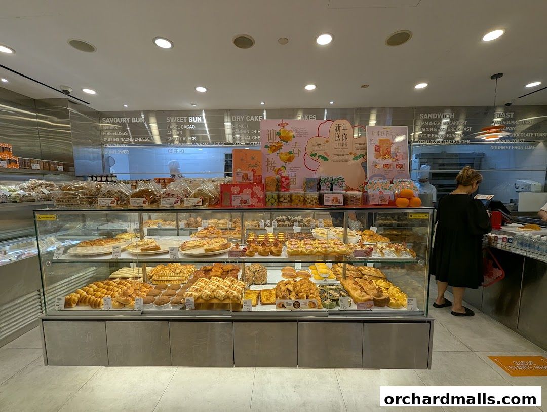 A display of freshly baked bread and pastries at BreadTalk, with a menu board above.
