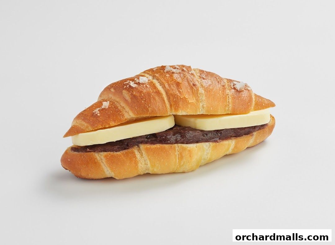 A croissant sandwich filled with red bean paste and butter, sprinkled with salt.
