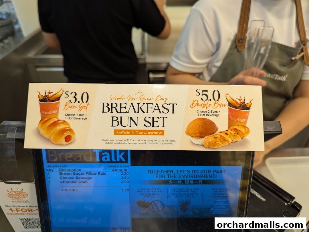A close-up of a BreadTalk counter displaying breakfast set promotions and a receipt.